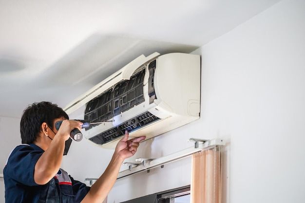 Technician servicing a wall-mounted aircon unit